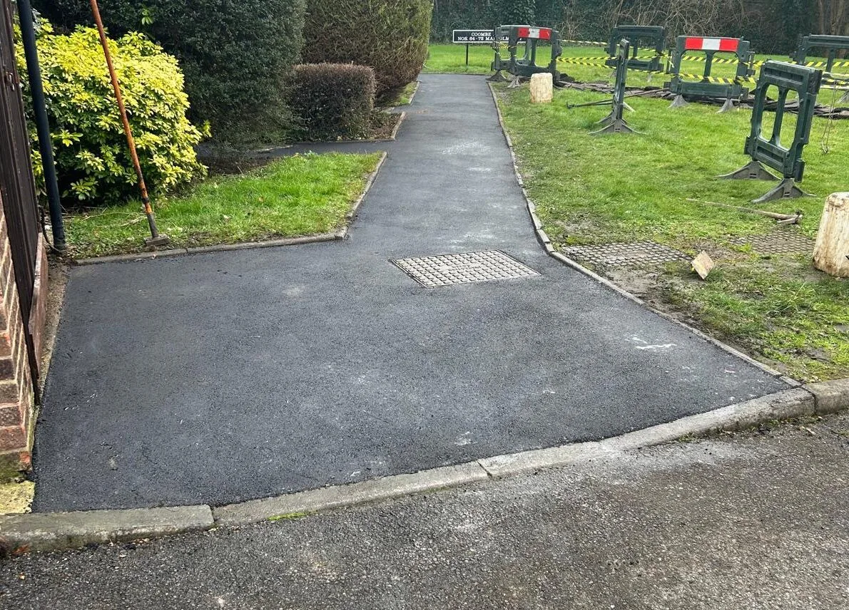 A new tarmac path with a drainage gully set into the surface
