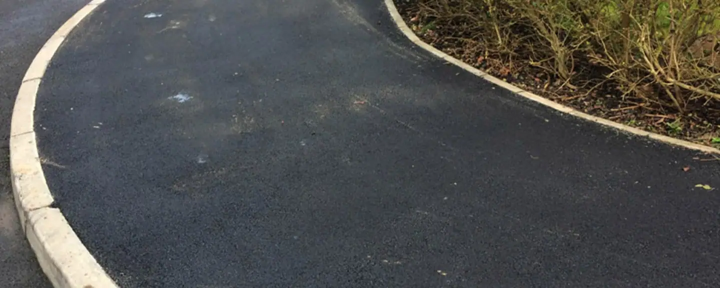 A new tarmac footpath with a fresh kerb edge — Path Resurfacing in Gravesend by Meads Resurfacing