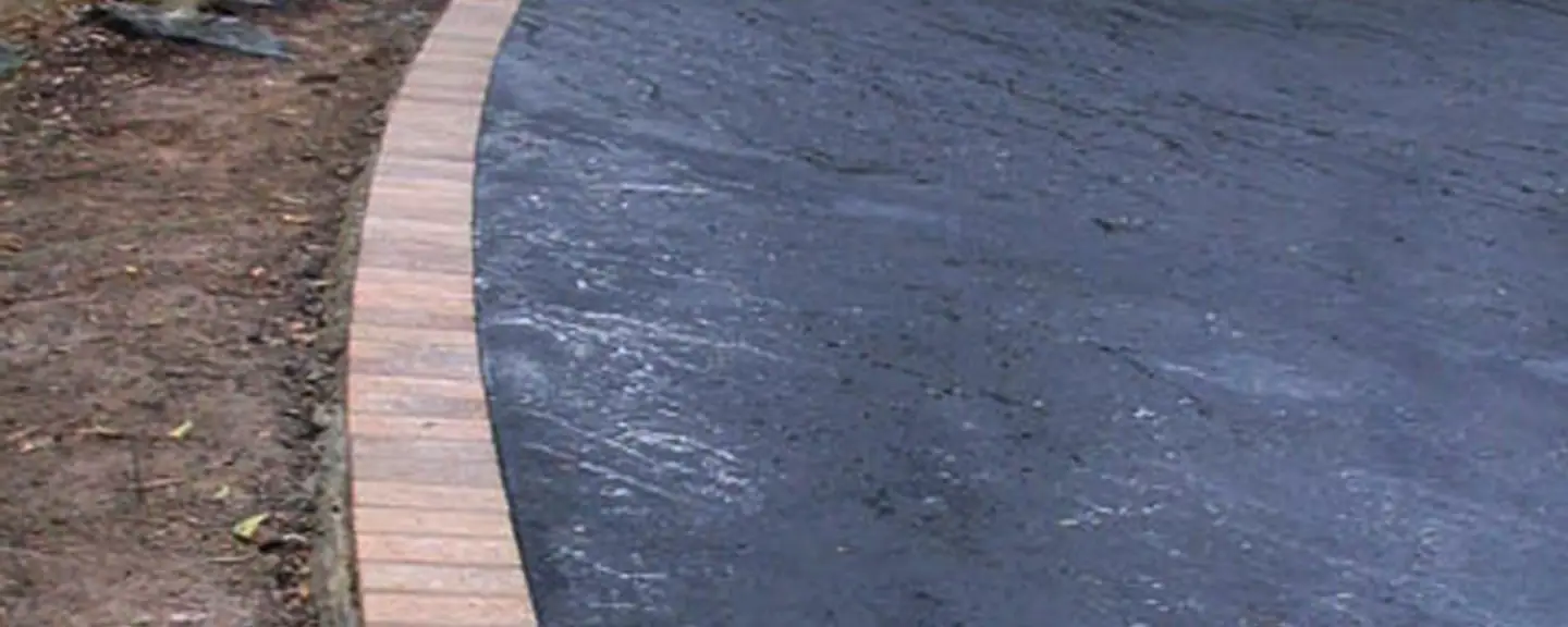 A newly surfaced footpath beside a wall — Path Resurfacing in Hounslow by Meads Resurfacing