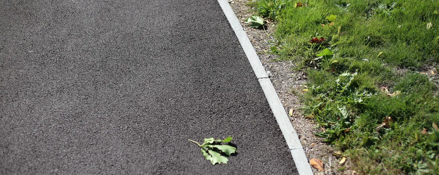 A path edged where the tarmac meets the grass — Path Resurfacing in Langley by Meads Resurfacing