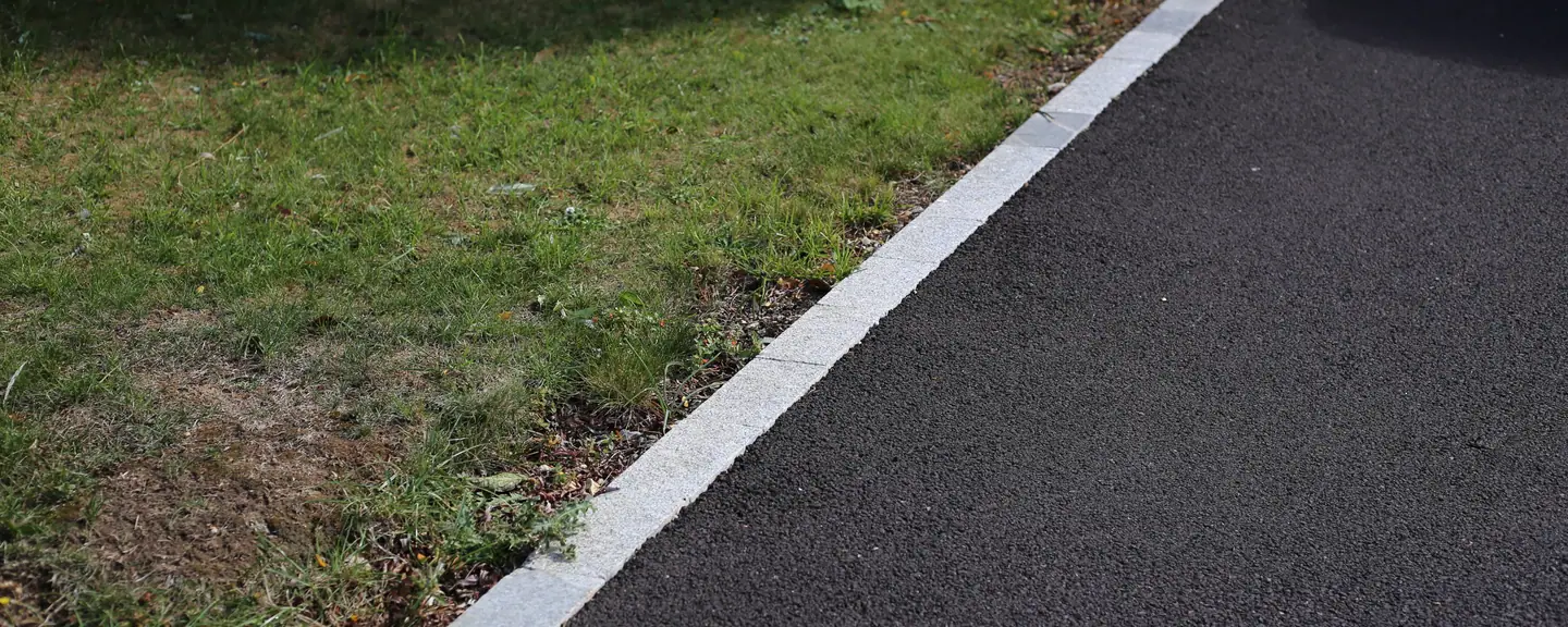 A kerbed path edge against a grass verge — Path Resurfacing in Cobham by Meads Resurfacing