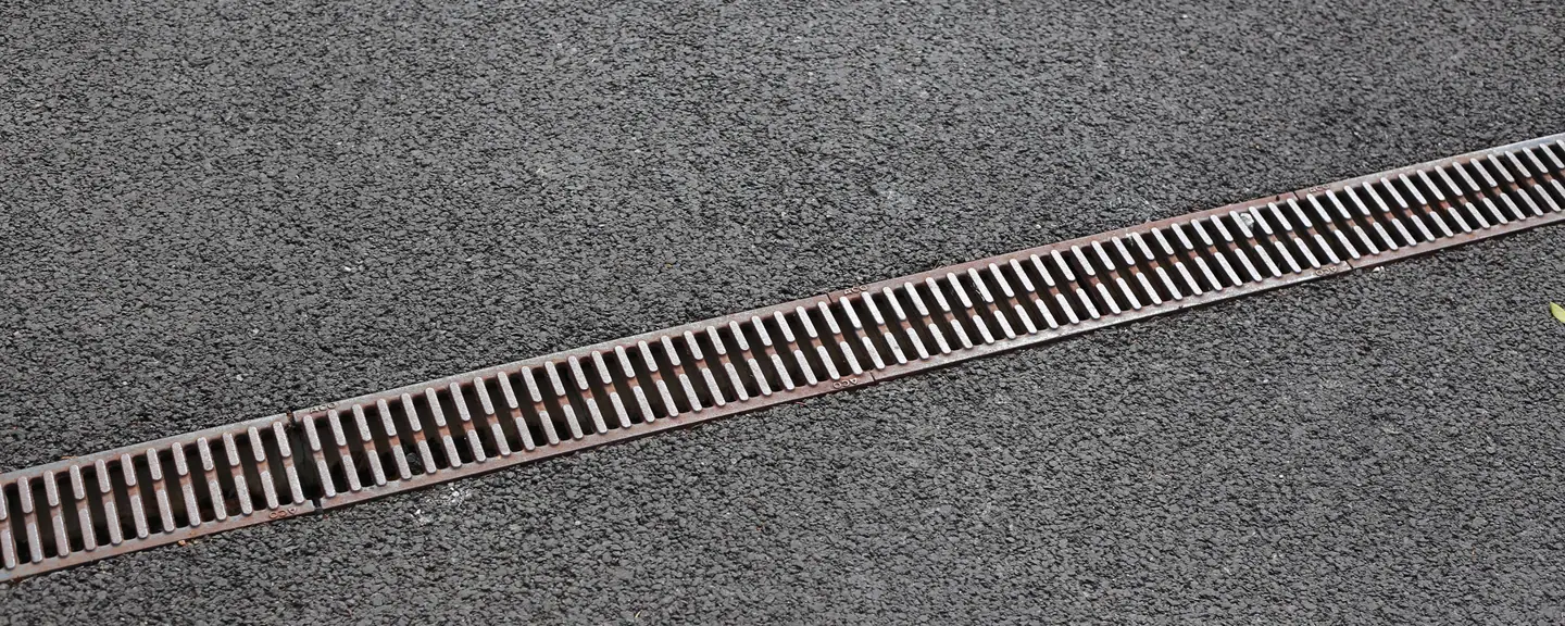 A drainage channel set into a tarmac path — Path Resurfacing in Croydon by Meads Resurfacing