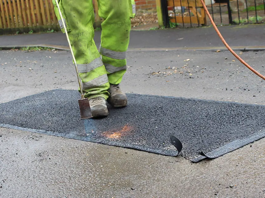 Broken tarmac being lifted out before filling