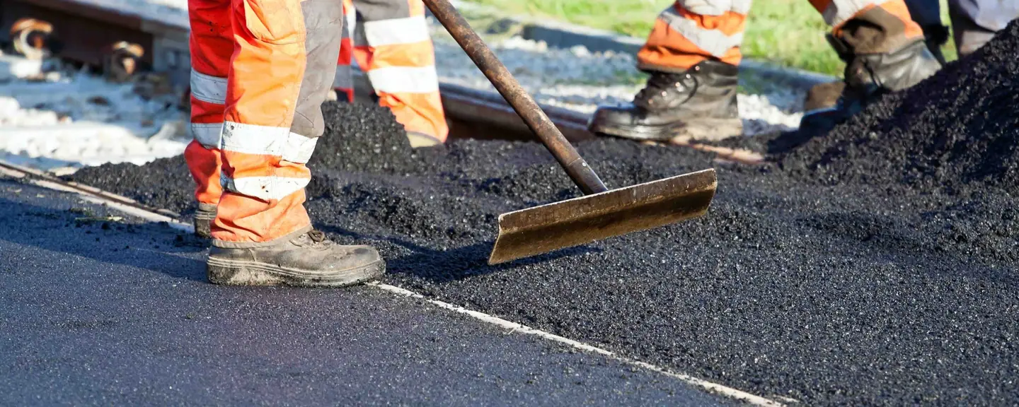 Hi-vis operatives spreading a new asphalt layer — Road Resurfacing in Barking by Meads Resurfacing