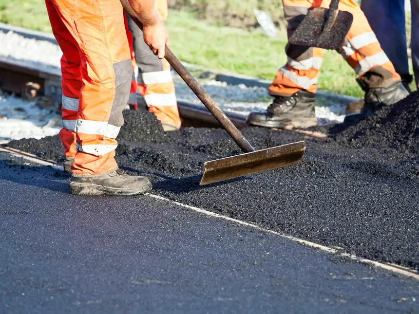 Hi-vis operatives spreading a new asphalt layer