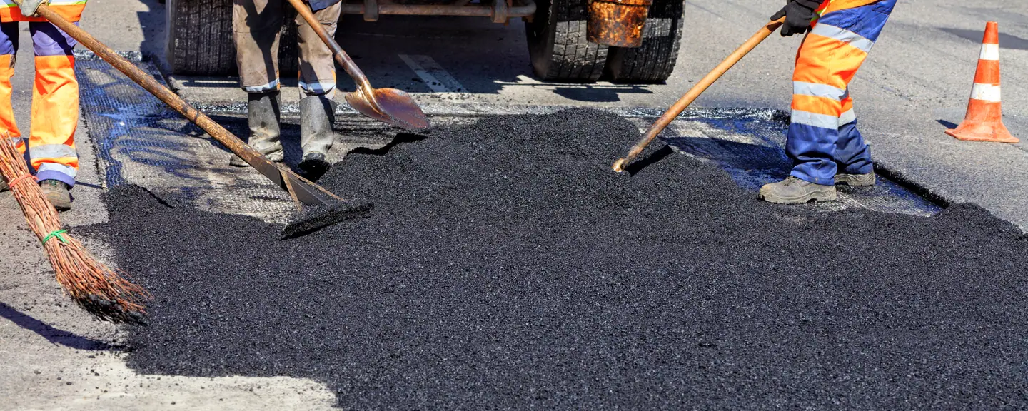 A crew shovelling asphalt into place — Road Resurfacing in Ealing by Meads Resurfacing