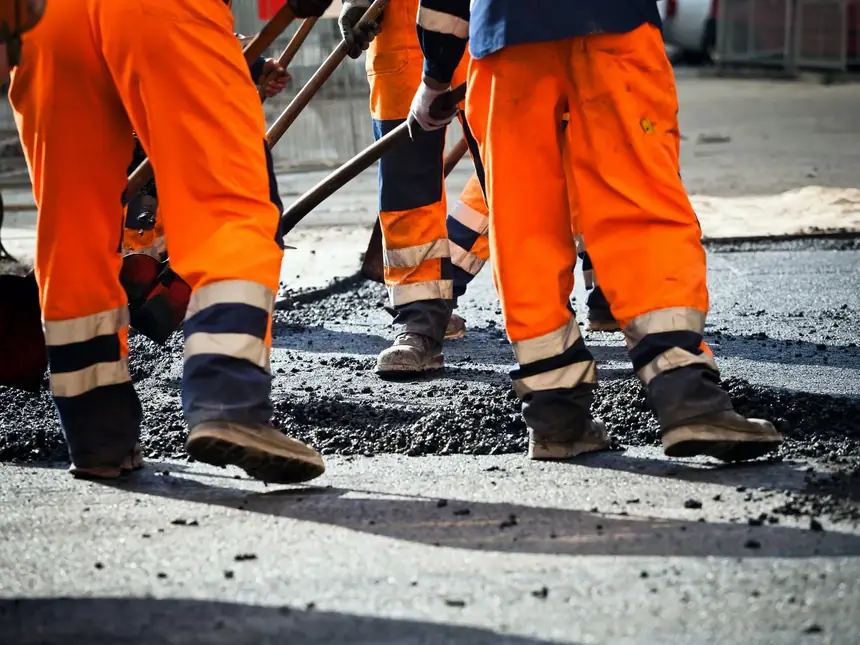 A team spreading tarmacadam across a carriageway