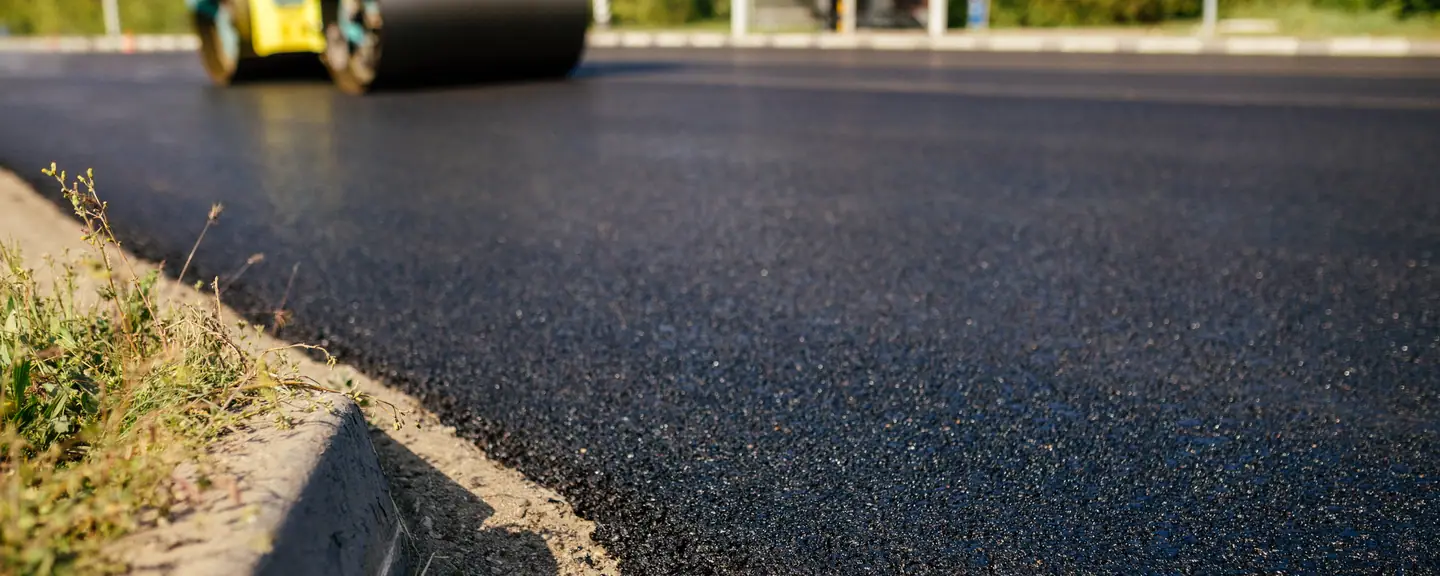 A roller working fresh hot asphalt — Surface Dressing in Leyton by Meads Resurfacing