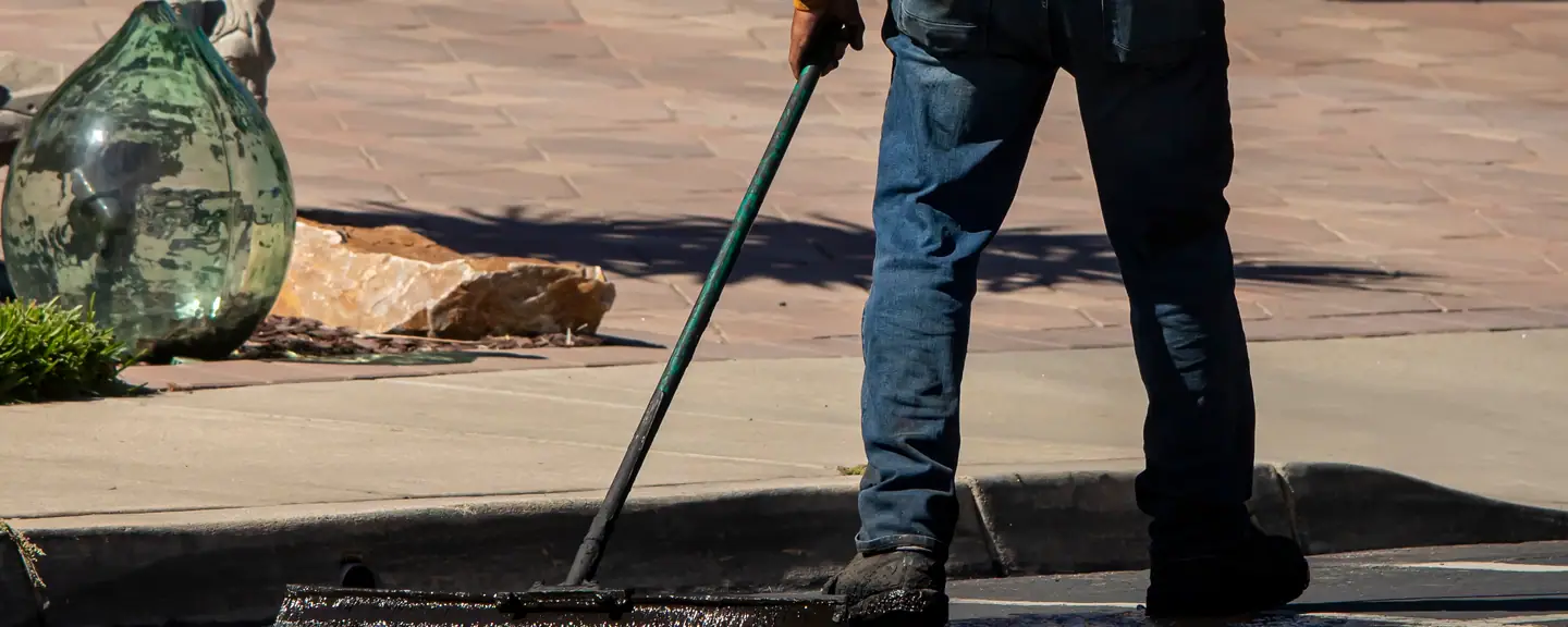 Sealant spread with a long-handled squeegee — Surface Dressing in Dagenham by Meads Resurfacing
