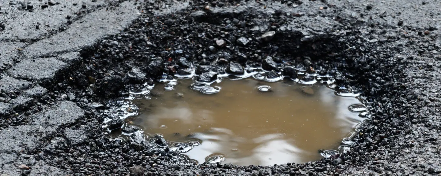 A patch repair cut into a road surface — Tarmac Asphalt Repairs in Ealing by Meads Resurfacing