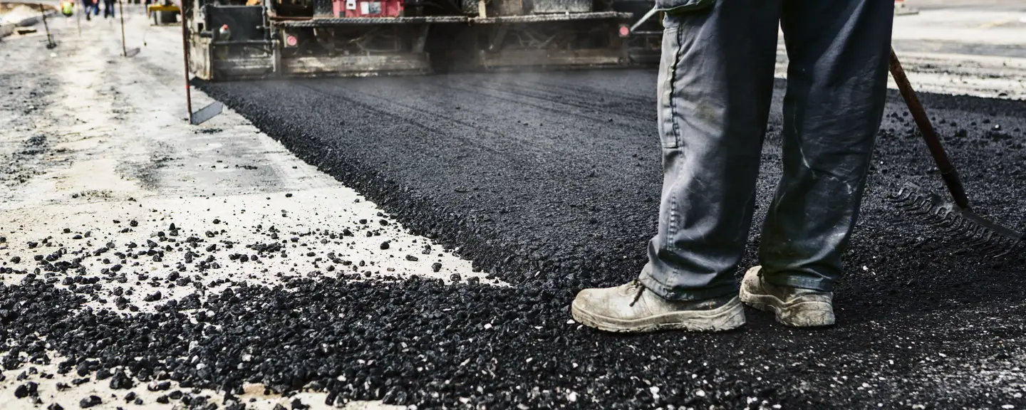 Loose tarmac behind a paving machine — Tarmac Contractors in Putney by Meads Resurfacing