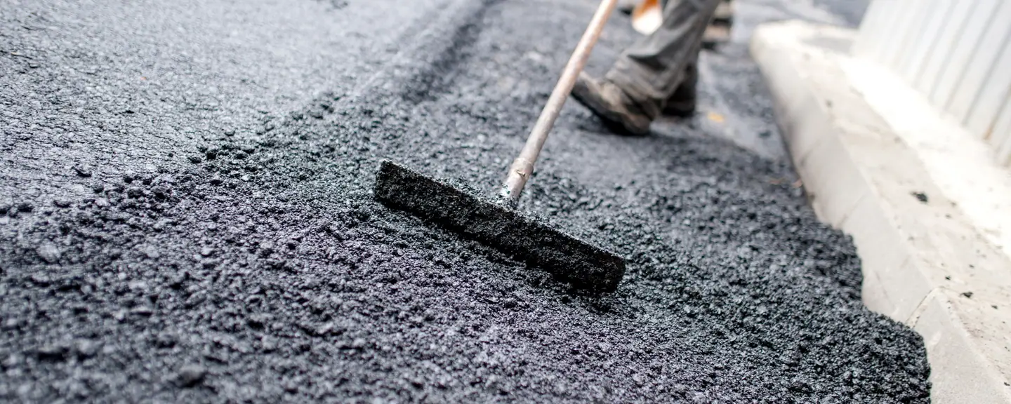 A contractor raking tarmac level — Tarmac Contractors in Hackney by Meads Resurfacing