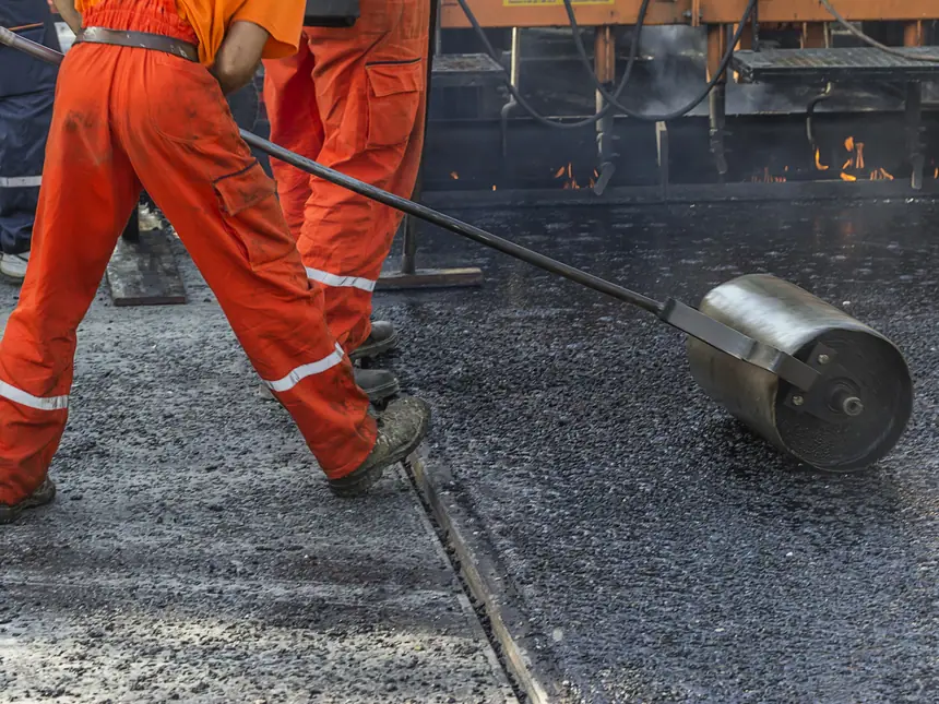 Tarmac being tamped against a kerb
