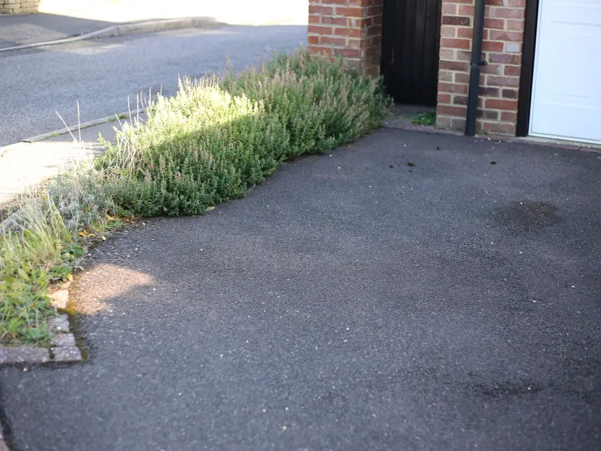A new tarmac driveway laid up to a brick house