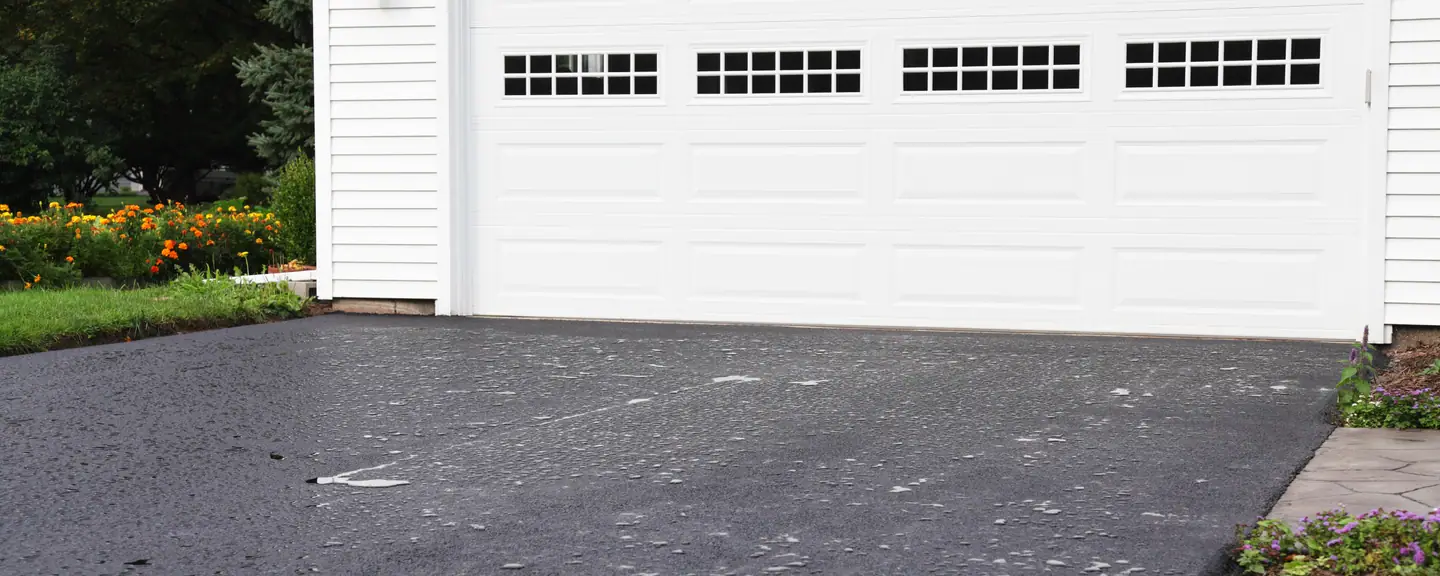 A tarmac driveway up to a double garage — Tarmac Driveways in Brompton by Meads Resurfacing